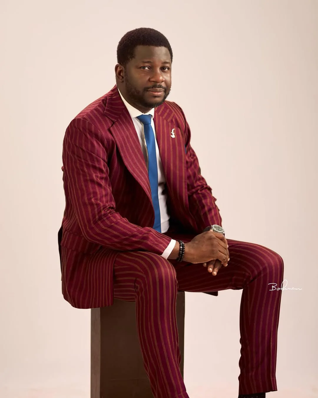 Akin Akinpelu, Ph.D., Amb., FLPi seated in a burgundy suit